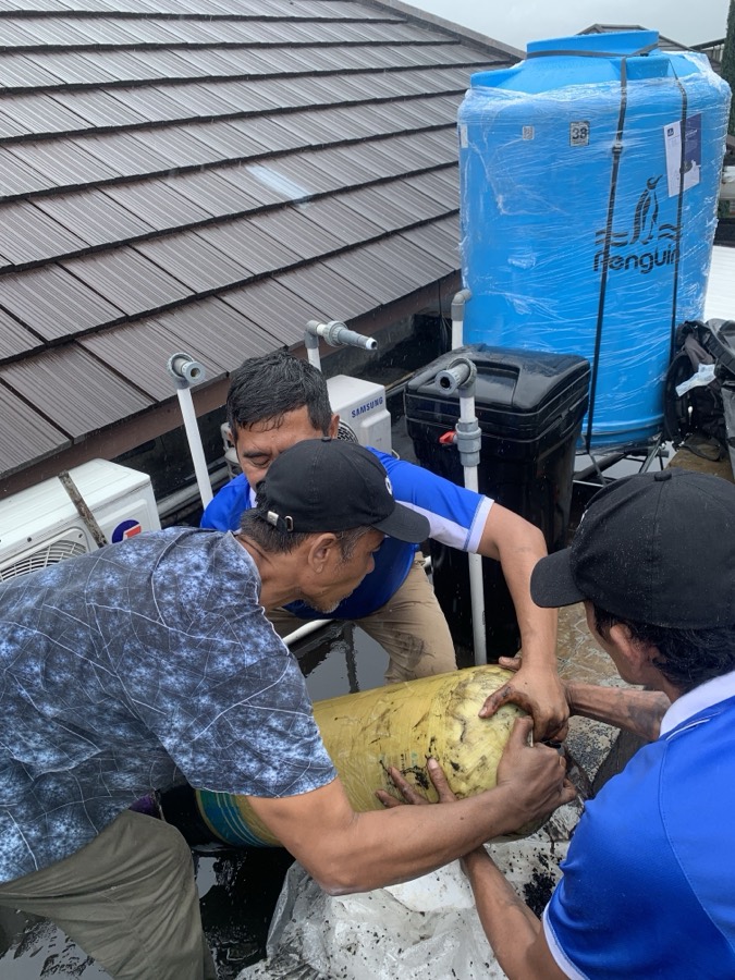 Tim Allir mengangkat tabung filter ke atap bersama-sama.