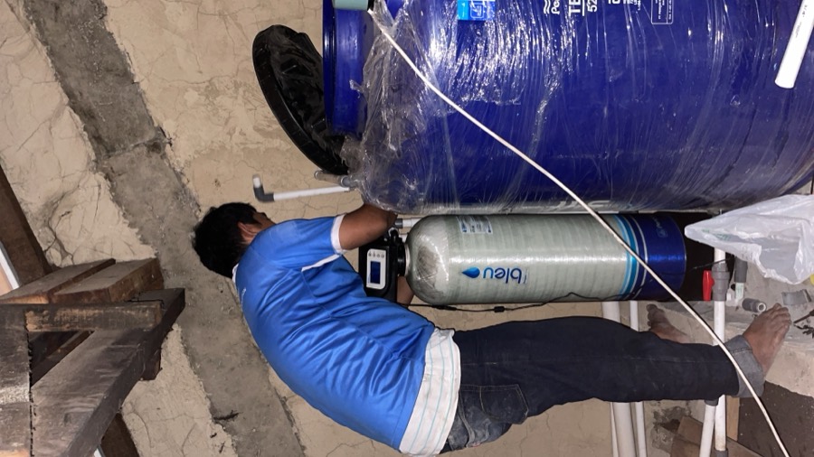 Instalasi tabung filter di dalam ruang utilitas rumah.