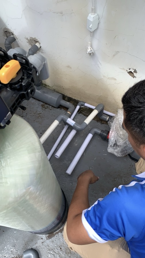 Pengerjaan jalur pipa PVC di samping tabung filter.